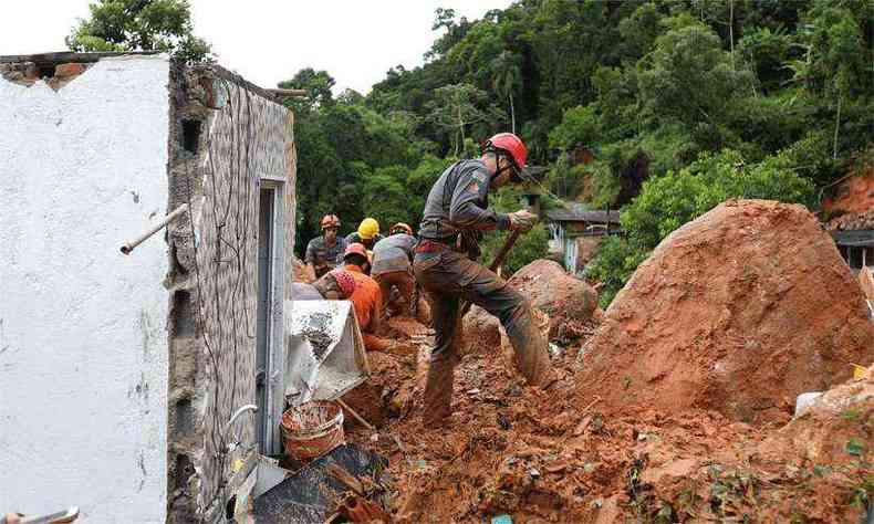 Bombeiros buscam vtimas de um deslizamento de terra na favela Morro do Macaco Molhado, no Guaruj(foto: AFP / GUILHERME DIONIZIO)