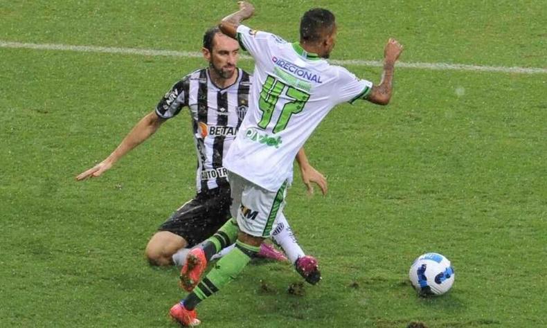 Zagueiro Godn, do Atltico, em lance com Paulinho, do Amrica, no jogo pela Libertadores