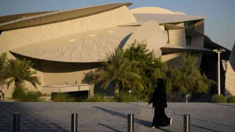 Mulher anda perto do Museu Nacional do Catar