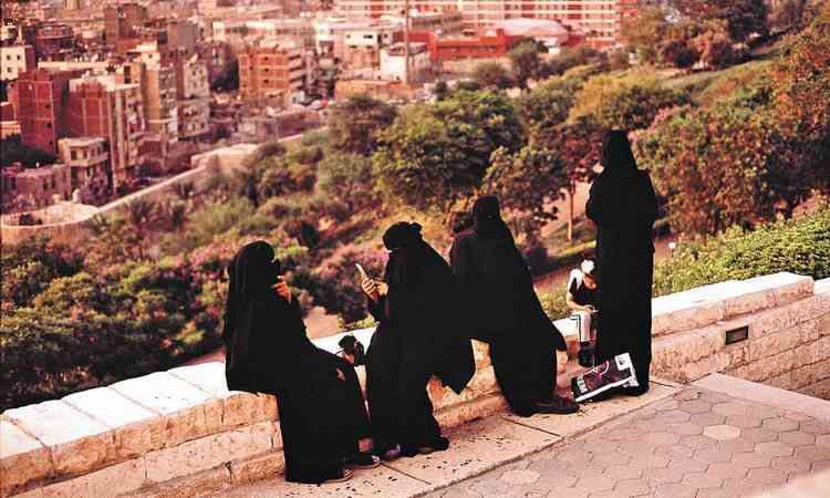 Foto de Julia Baumfeld mostra mulheres de preto, usando o celular, no Oriente Médio

