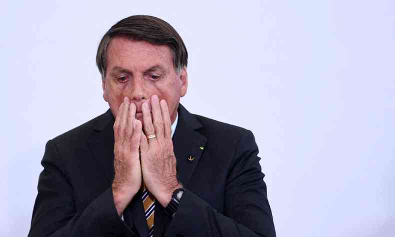 Jair Bolsonaro com as mos no rosto em expresso de preocupao