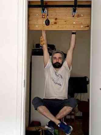 Felipe, de 35 anos, marido de Tas, montou uma 'academia' na porta da cozinha para se exercitar(foto: Arquivo pessoal)