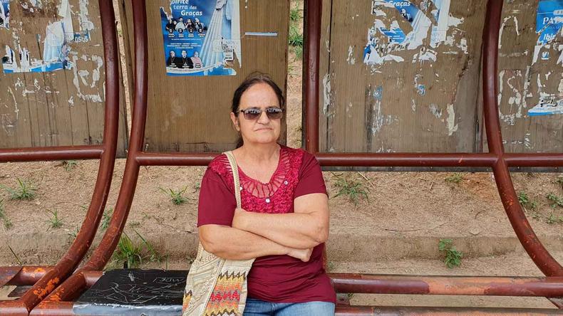 A bordadeira Helena em frente a um ponto de nibus espera pela linha do seu bairro