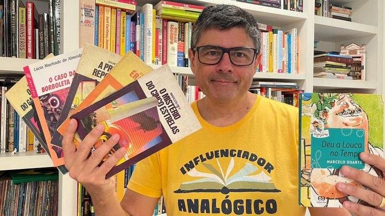 O escritor Marcelo Duarte segura livros da s�rie Vaga-Lume