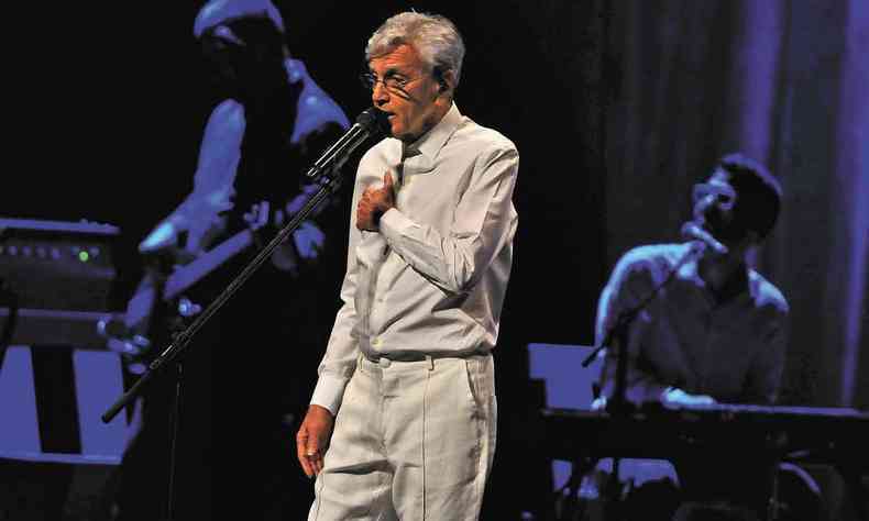 Vestido de camisa e cala brancos, Caetano Veloso canta no palco do Grande Teatro do Palcio das Artes 