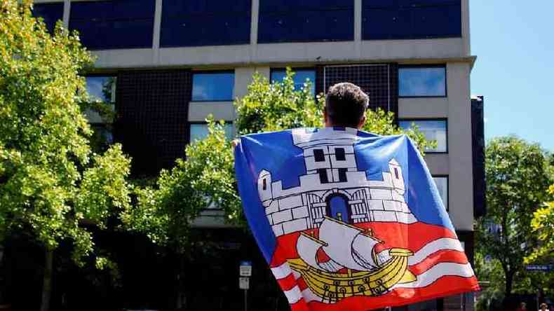 F enrolado na bandeira srvia olha para o Park Hotel em Melbourne, onde Novak Djokovic estaria detido