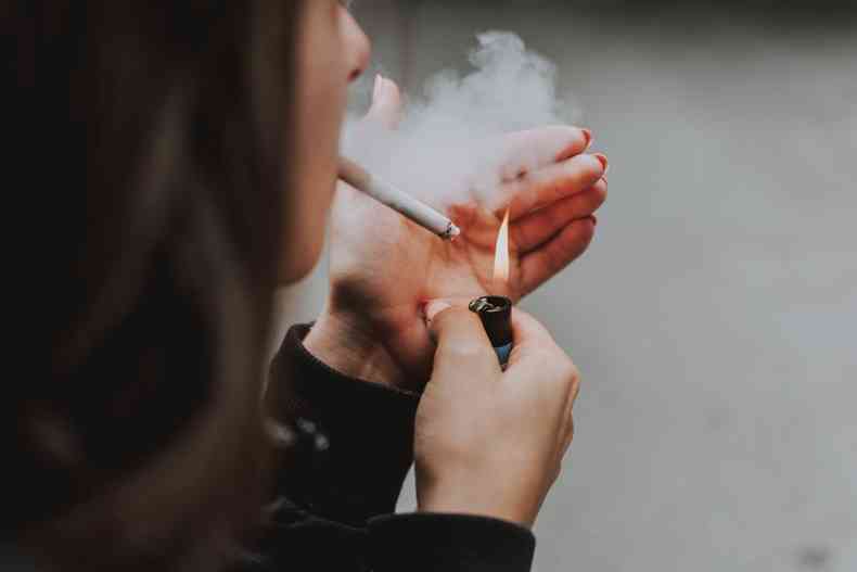 Mulher acendendo um cigarro 