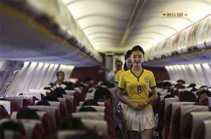 Comissrias caminham pelo avio com a camisa da seleo brasileira (foto: REUTERS/Wong Campion)