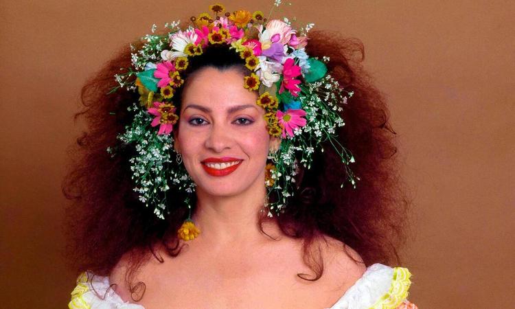 Clara Nunes tem flores na cabea e usa vestido branco, com babados no decote, em ensaio fotogrfico para o disco 'Nao'