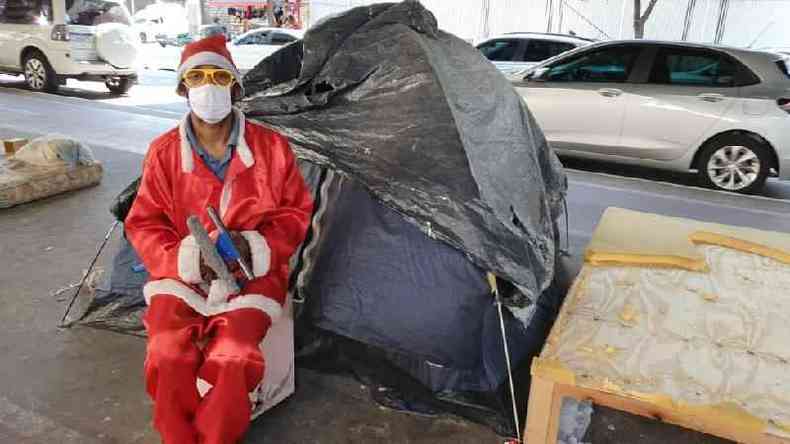 Gleidson Oliveira Lima vestido de Papai Noel em frente a sua barraca coberta por lona, sob o Minhoco, no centro de So Paulo