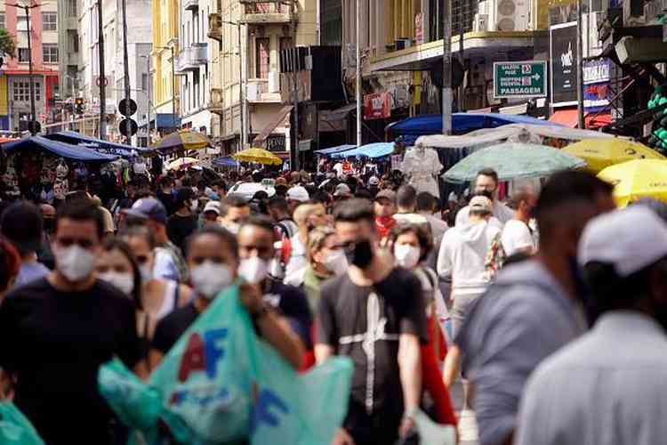 Pessoas com mscaras andando em rua 