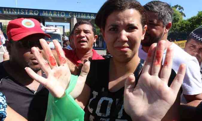 Uma das manifestantes agredida pelo grupo contrrio ao ex-presidente Lula mostra o sinal das agresses (foto: Roberto Parizotti/ CUT)