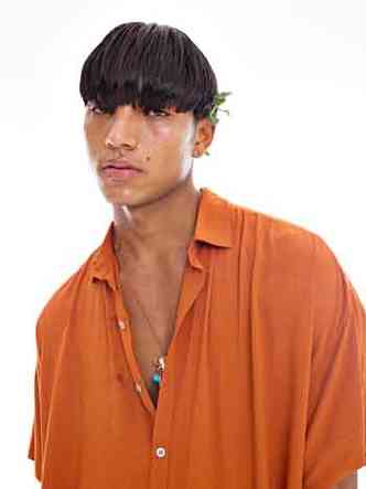 Modelo indgena Noah Alef veste blusa laranja