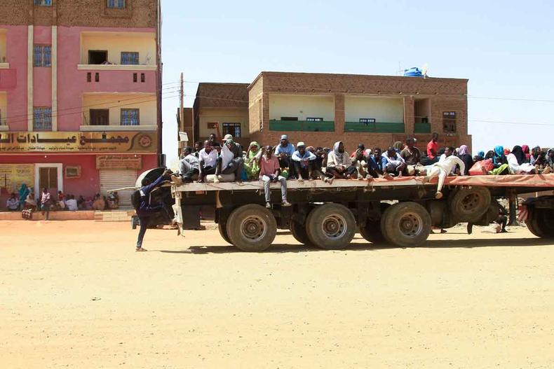 Na traseira de um caminhão, moradores fogem de batalhas de rua entre as forças de dois generais sudaneses em Cartum(foto: AFP) Na traseira de um caminhão, moradores fogem de batalhas de rua entre as forças de dois generais sudaneses em Cartum