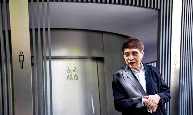 O arquiteto Tadao Ando, com as mãos cruzadas, diante de banheiro público de Tóquio projetado por ele