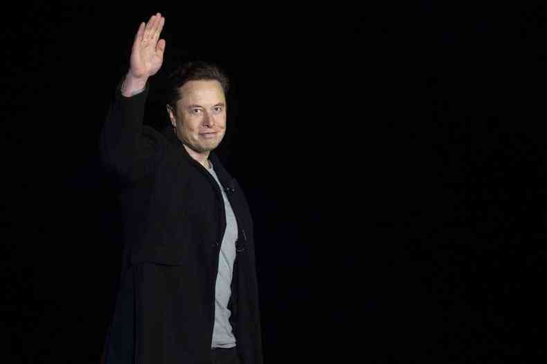Elon Musk acena com o braço esquerdo para o alto
