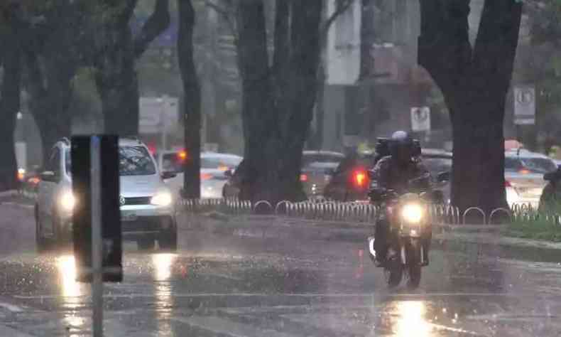 Pista molhada e um carro e uma moto passando