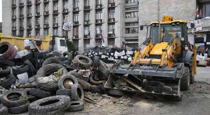 Trator limpa barreira feita em frente  sede da administrao local de Donetsk(foto: Maxim Zmeyev/Reuters)