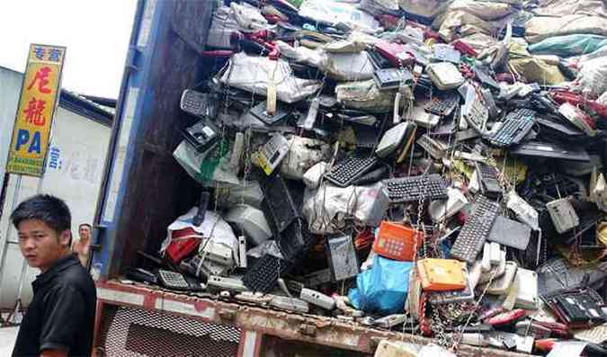 Trabalhadores descarregam caminho com lixo eletrnico(foto: AFP PHOTO / JOHANNES EISELE )