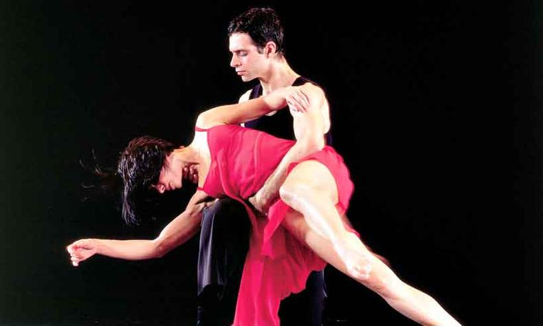 Casal de bailarinos com figurinos vermelhos dana Lecuona, coreografia do Grupo Corpo