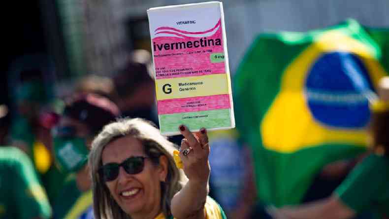 Mulher em manifestao pr-Bolsonaro segura cartaz com desenho de caixa de ivermectina