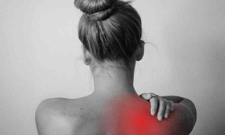 mulher de coque, de costas, com a mo no ombro, um ponto que sente dor 