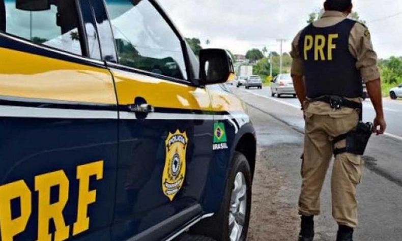Policial ao lado de viatura
