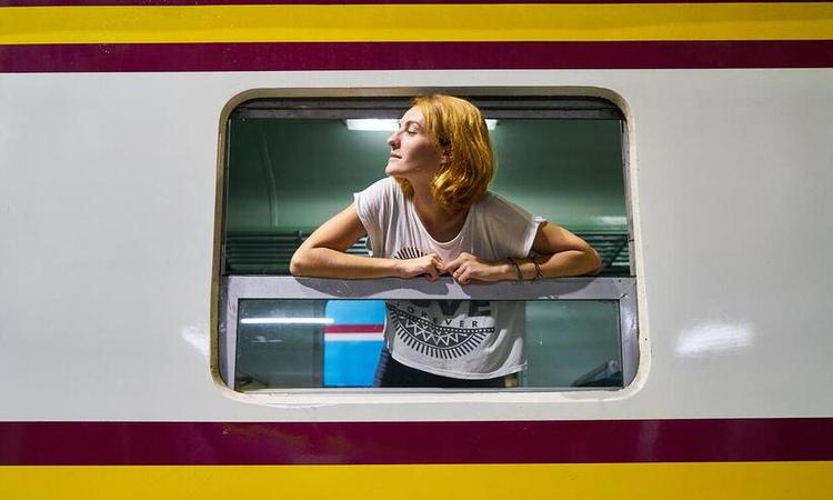 moça debruçada na janela de um trem