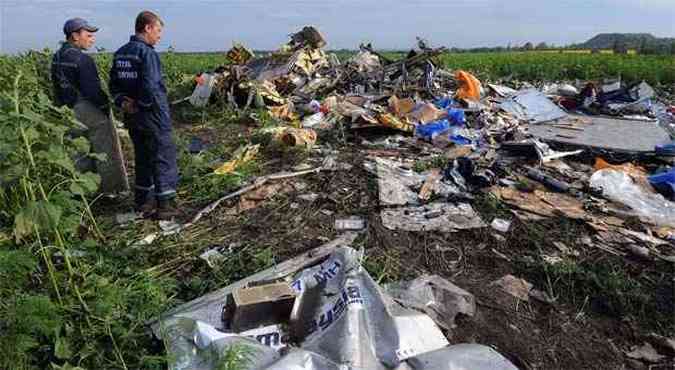 Empregados do Servio de Emergncia de Estado da Ucrnia observam destroos do voo MH17 prximos da cidade de Rassipnoe(foto: AFP PHOTO / DOMINIQUE FAGET )