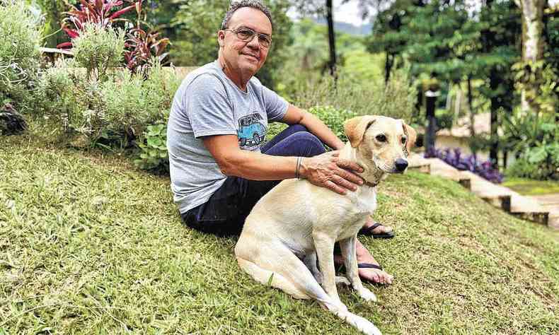 artista plstico Mrcio Lambert no jardim de casa com seu cachorro