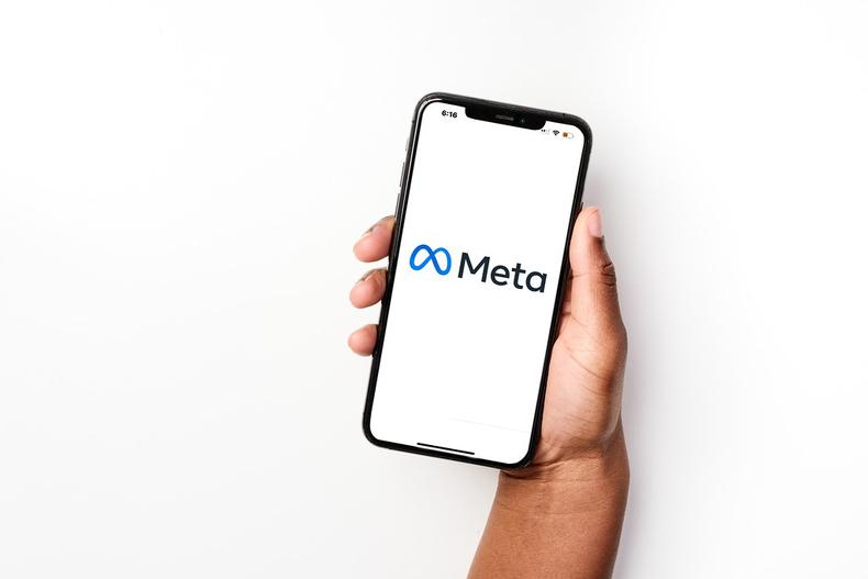 mão segura celular com logomarca da Meta na tela