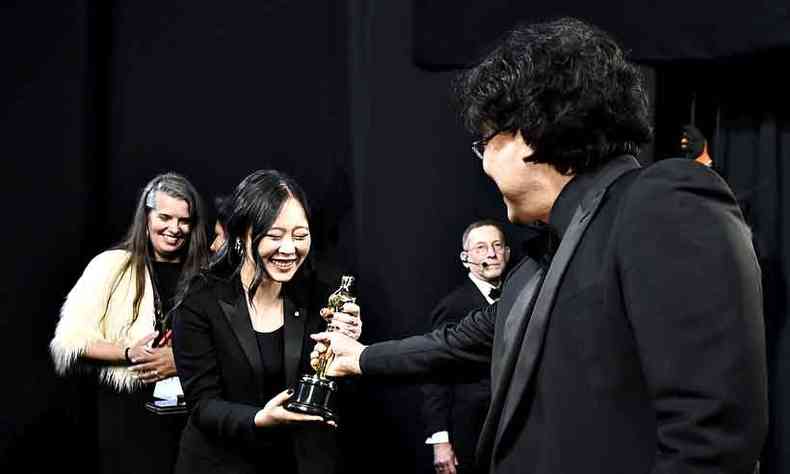 A tradutora sul-coreana Sharon Choi 'recebe' o Oscar das mos do diretor Bong Joon-ho, que discursou em sua lngua na festa do cinema, em Los Angeles(foto: Matt Petit/AFP)