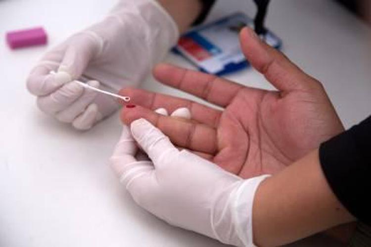 A man undergoes a rapid VIH test during the Gay Pride Parade in Santiago on June 23, 2018.   The initiative aims to encourage prevention, as there is concern about the alarming increase of new HIV infections (Acquired Immunodeficiency Virus) in the country. / AFP / CLAUDIO REYES