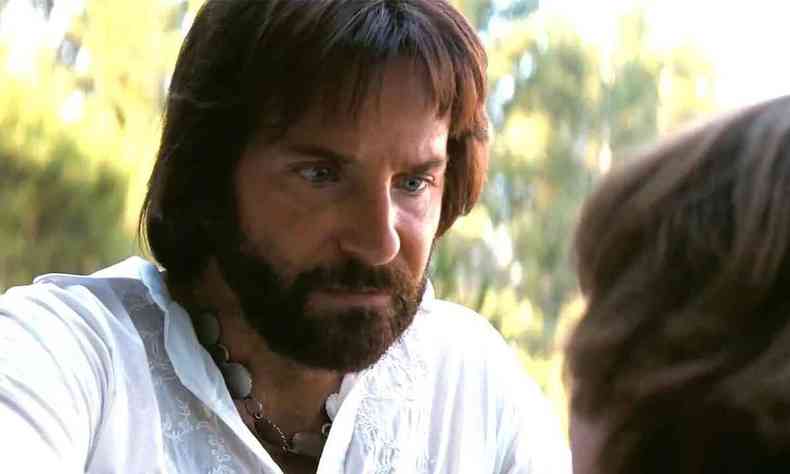 Bradley Cooper, de barba e tnica branca, no filme Licorice Pizza