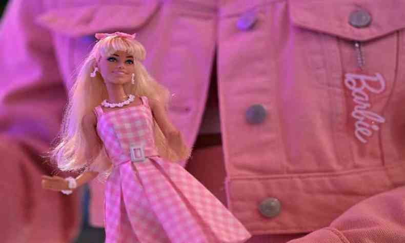 Uma mulher segura uma boneca Barbie depois de assistir ao filme 
