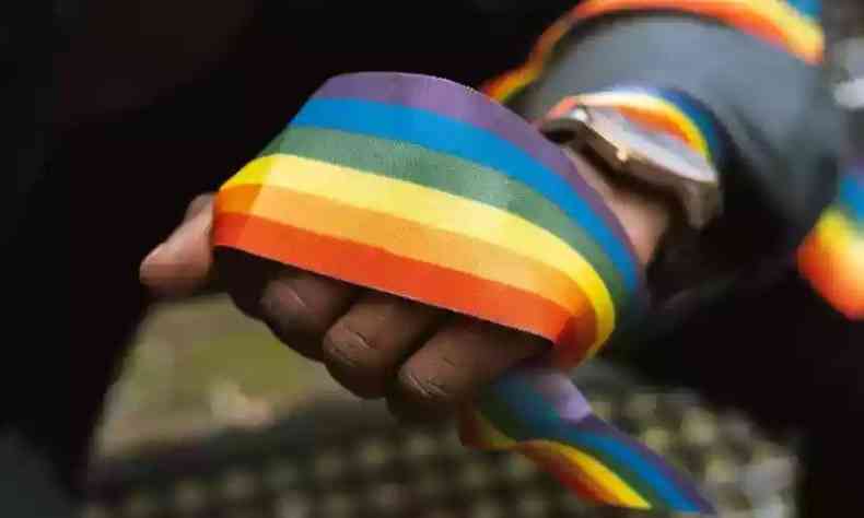 Mo segurando uma faixa com as cores do arco-ris