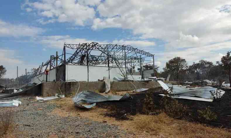 Foto mostra estrutura do galpo destruda e telhas retorcidas no cho