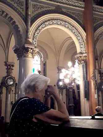 Gisélia Araújo Costa, de 96 anos, em oração na igreja