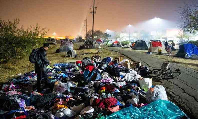 Evacuados vasculham uma pilha de roupas em um acampamento no estacionamento do Walmart em Chico, Califrnia(foto: JOSH EDELSON/AFP )