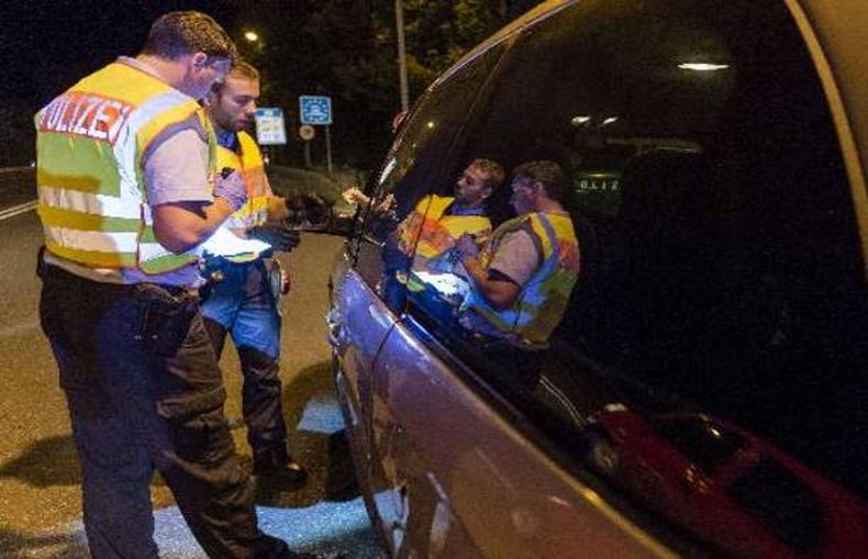 Policiais vistoriam carro vindo da Hungria, na fronteira entre Alemanha e ustria(foto: Guenter Schiffmann/AFP )