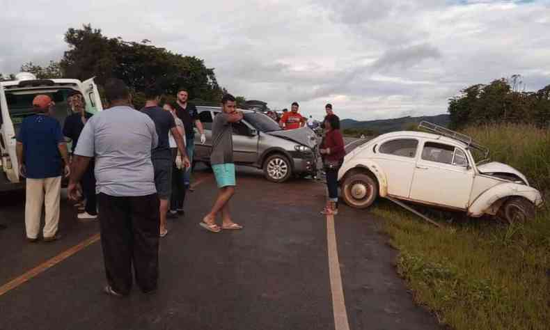 Fusca e outro carro com a frente destruda; h pessoas no local