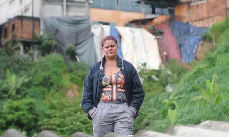Zélia Rodrigues, moradora do beco dos Fagundes, em Betim, diante de uma das casas sob risco de desabamento com as chuvas