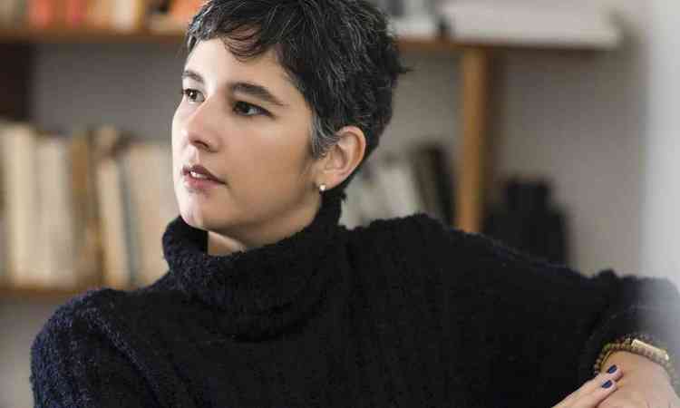 Vestindo blusa preta, a escritora Marcela Dants olha para o lado