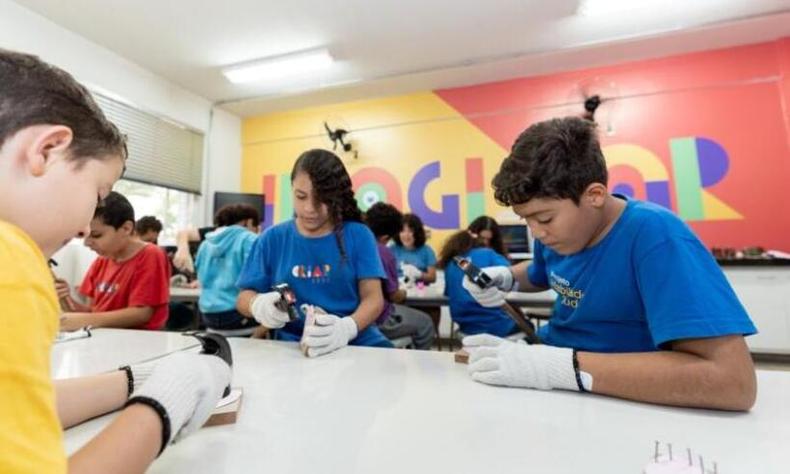 menina sorrindo junto a colegas em sala de aula
