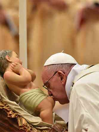 Papa Francisco beija o menino Jesus durante a Missa do Galo na Baslica de So Pedro(foto: VINCENZO PINTO / AFP)