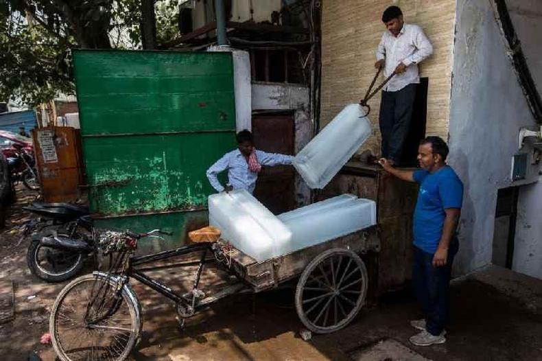 Vendedores transportando blocos de gelo em Dlhi