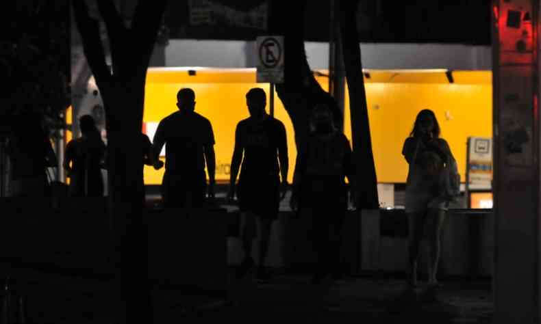 Pedestres atravessam calada com pouca iluminao na Praa da Savassi, em Belo Horizonte