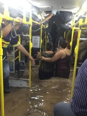 Passageiros de nibus inundado so retirados pelo teto(foto: Divulgao)