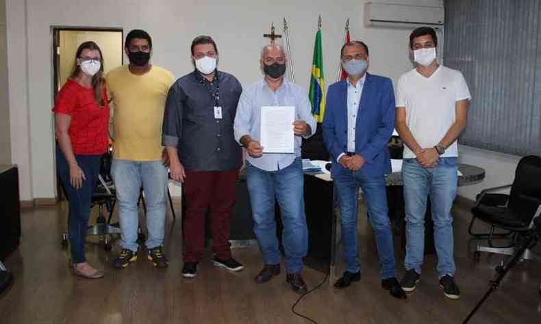 O prefeito Elias Diniz (ao centro, com documento) recebeu a obra ao lado de representantes da Vale e da guas de Par de Minas(foto: Prefeitura Municipal de Par de Minas/Divulgao)