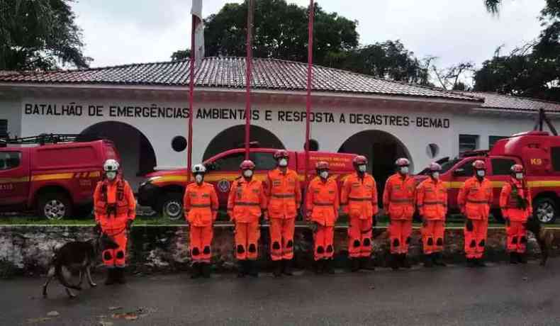 Bombeiros em fila a frente de um prdio 